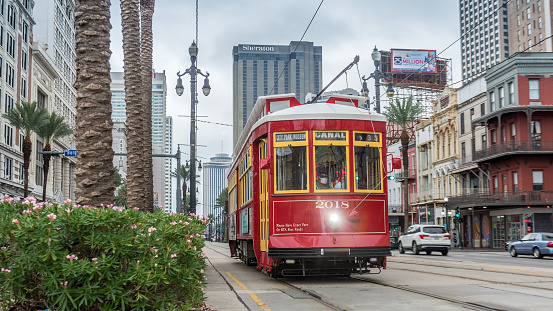 New Orleans, LA, USA - June 27, 2022: View of traditional Red Streetcar driving down by Canal Street, New Orleans. Streetcars in New Orleans have been an integral part of the city's public transportation network since the first half of the 19th century.