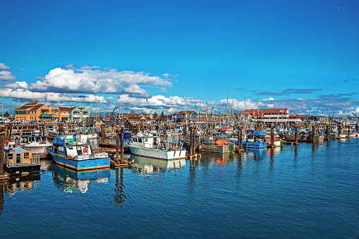 Fishing Boats in Marina and a cloudy sky. This marina is located in the Steveston area of Richmond. The fishing village formed in this place was the first settlement on the territory of  Richmond