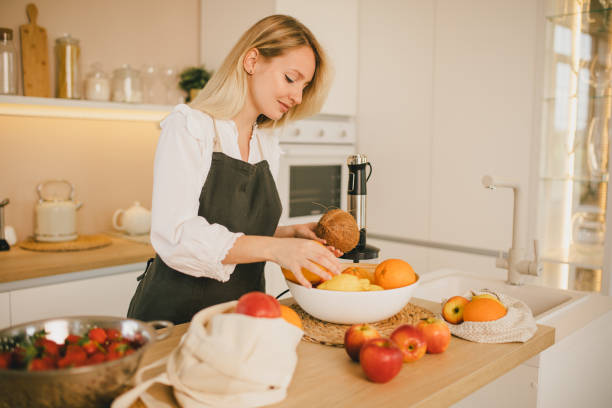 istock Millennial woman preparing ingridients for making smoothies at the kitchen 1407014502