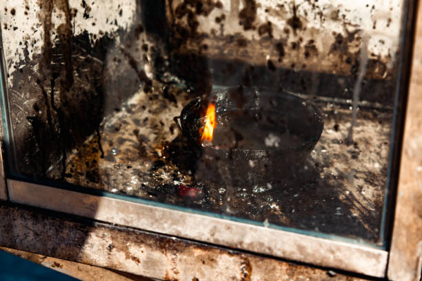 Kolomna, Russia -  May 4, 2024: The eternal flame in the memorial park against the backdrop of birches. Flames escape from a five-pointed star. Sunny day.
