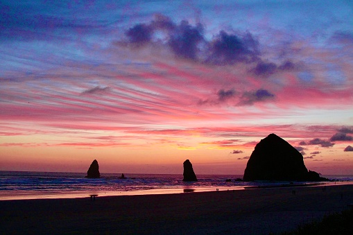 Cloud colored just after sunset over Cannon Beach, Oregon and Haystack Rock