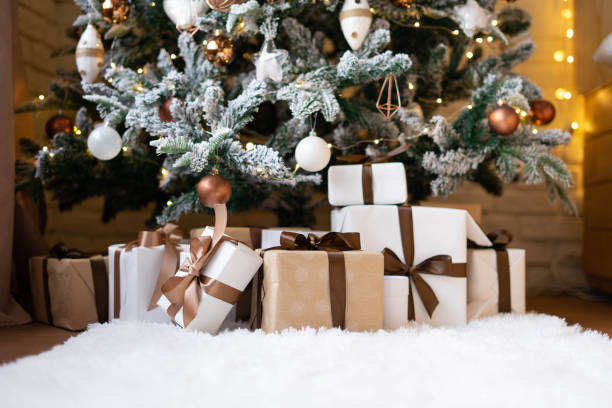 istock White and craft wrapped gifts under the Christmas tree on a white fluffy carpet. 1407020929