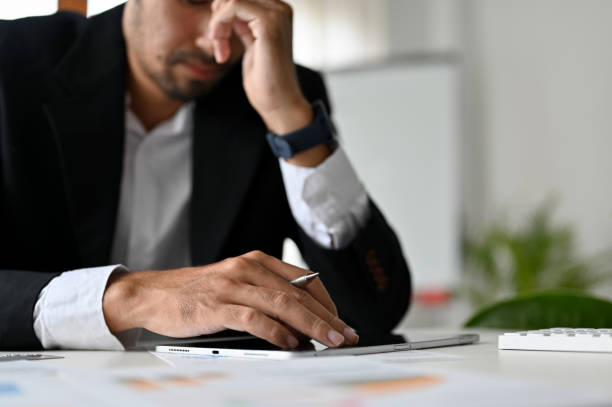 istock Stressed and failure asian businessman at his office desk. cropped image 1407024490