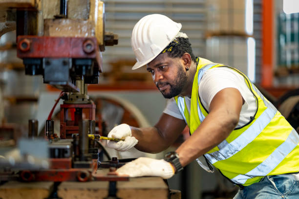 istock African American industrial worker is using hydraulic power press machine to make metal and steel part while working inside the metal sheet galvanized roof factory for safety industry concept 1407026041