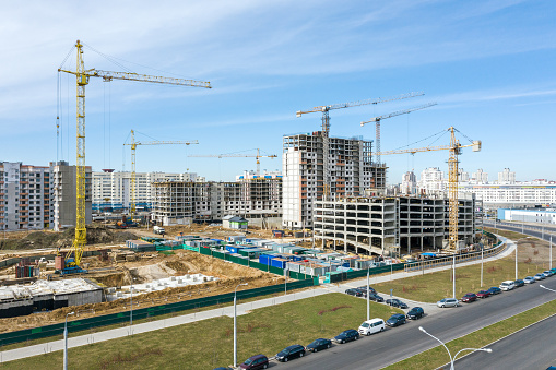 residential area under construction. building site with cranes on sky background. drone photo.