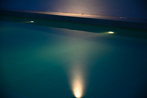 Modern swimming pool for family lifestyle at night. Pool lighting design