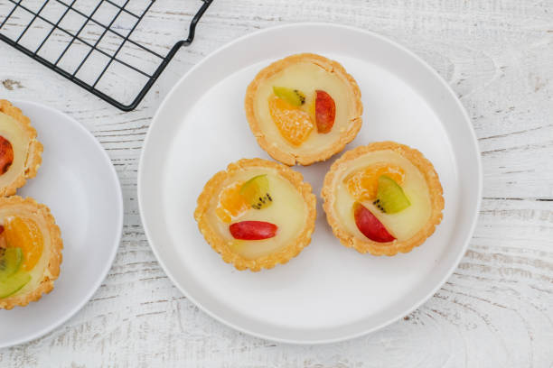 Small fruit pia cake on a textured white background. Kue Pia Buah.