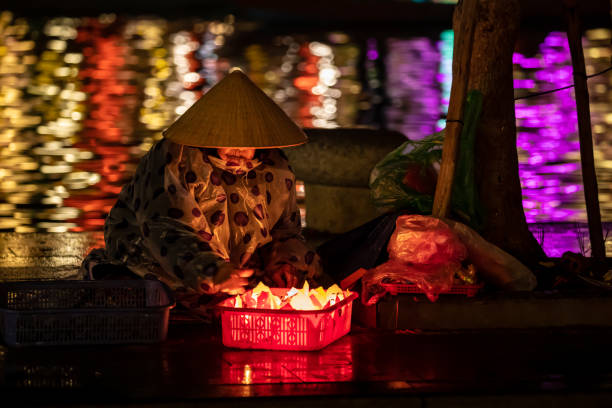 Old Woman selling lanterns in hoi an Hoi An, Da Nang, Vietnam - December 12, 2019: An old Woman are selling traditional lanterns in Hoi An thu bon river stock pictures, royalty-free photos & images