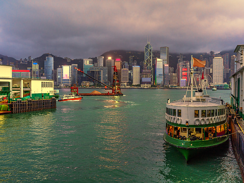 Hong Kong - June 29, 2022 : A fishing boat with banners and flags celebrating the 25th anniversary of Hong Kong's handover from Britain to China, at Victoria harbour, Hong Kong.