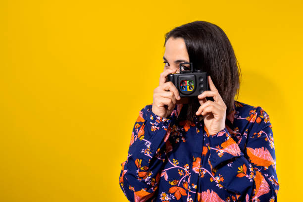 istock Young Woman Holding A Retro Camera 1407041601