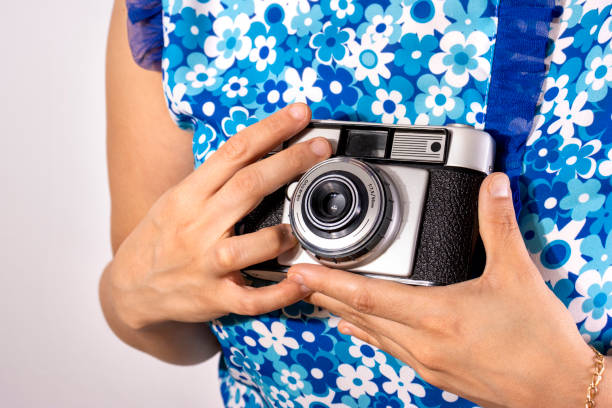 istock Young Woman Holding A Retro Camera 1407041615