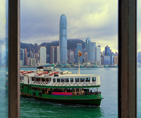 Traditional junk boat with a red sail on the background of the harbor on victoria island in hong kong