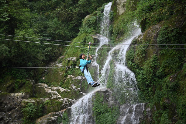 istock A girl zip-lining near a waterfall 1407043838