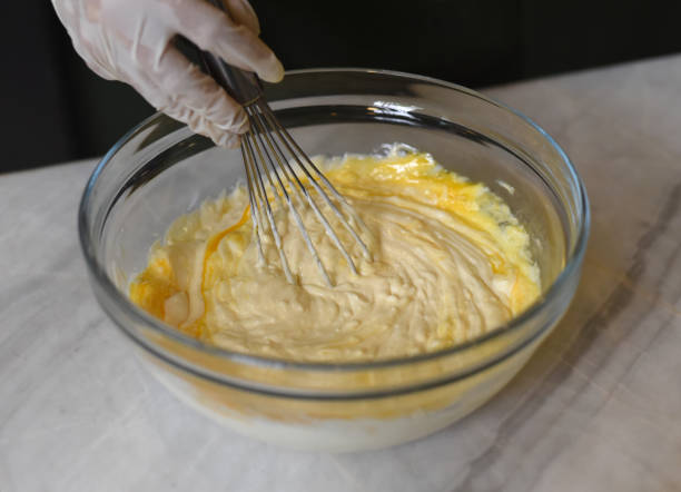 istock A hand in rubber glove stirring dough for a cake 1407045100