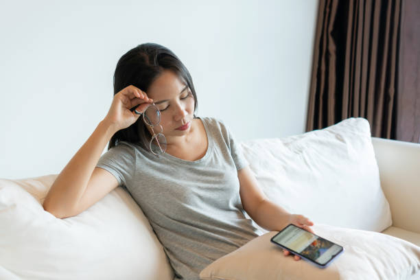 istock Tired young Asian woman taking off glasses, feeling eyestrain during using  mobile phone at home. Businesswoman suffering from dry eye syndrome, fatigue after long cellphone use. 1407046196