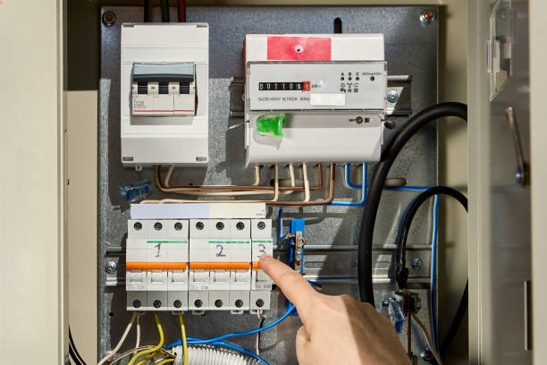 electrician switches circuit breaker in consumer unit of  fuse box and electric meter. - electrical junction box imagens e fotografias de stock