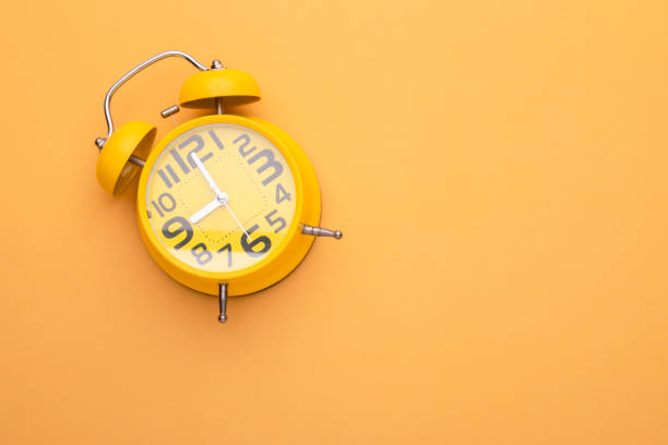 istock Old yellow alarm clock on bright color background 1407053994