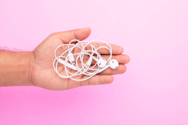 istock White tangle earphone in hand on pink background. Copy space for text or design 1407054559