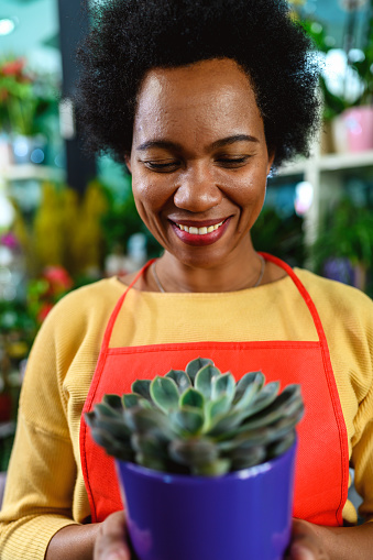 African-American woman with a cactus pot in her hands.