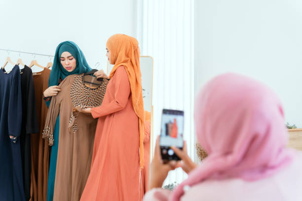 a group of muslim female friends take a video on their phones, friends shopping for clothes on their phones. - connection usa brooklyn bridge business imagens e fotografias de stock