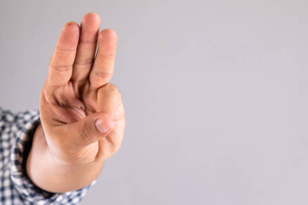 istock Hand showing three finger symbol on grey background with copy space 1407058474