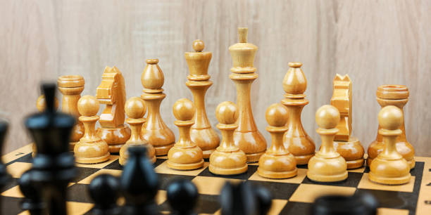istock Wooden white and black chess pieces stands on chessboard 1407060974