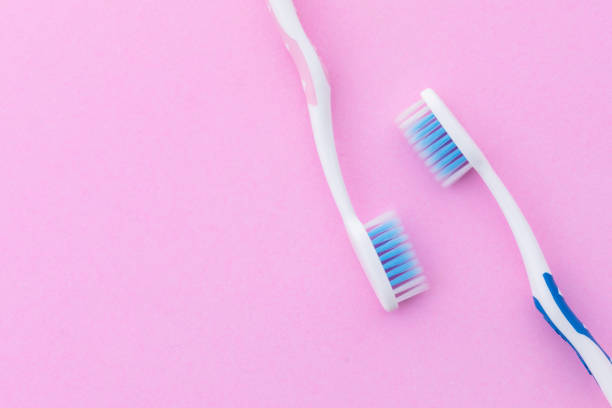 istock New pink and blue toothbrush on pink background with copy space for text or design. 1407062014