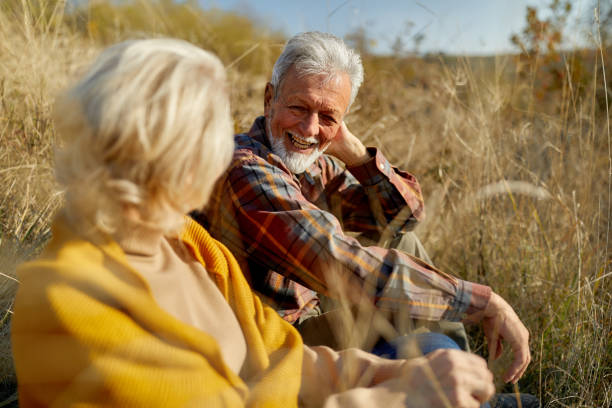 istock Happy mature couple talking during autumn day in tall grass. 1407063323
