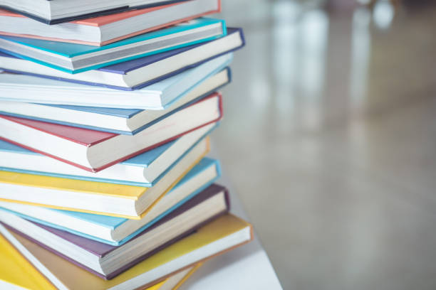istock Book stack on the table in the library room and blurred space of bookshelf background 1407064100