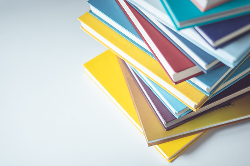 Stack of colorful file folders for holding document paperwork and organizing corporate business papers. The blank holders are a standard office supply. The empty rainbow color containers are an old-fashioned physical tool for storing important data but have many possible useful functions. Vertical format with copy space and no people.