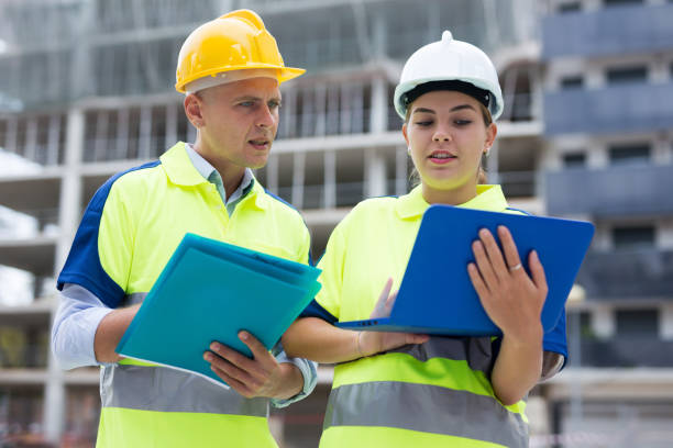 istock Two engineers are discussing an important project, holding a laptop and an estimate 1407064167