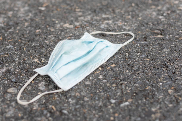 istock Old protective mask is on the road. After used and garbage concept 1407066236