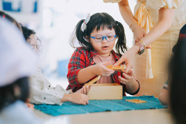 studente asiatico in età prescolare montessori che gioca blocco di legno in classe - child preschool toy playing foto e immagini stock