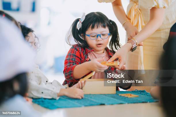 Asian Montessori Preschool Student Playing Wood Toy Block In Classroom Stock Photo - Download Image Now