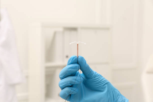 médecin tenant un dispositif contraceptif intra-utérin en forme de t sur fond flou, gros plan - iud photos et images de collection
