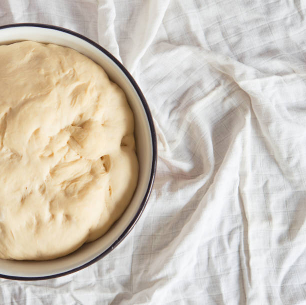 istock yeast dough for bread or pizza on a floured surface, with flour splash. Cooking bread. 1407069237