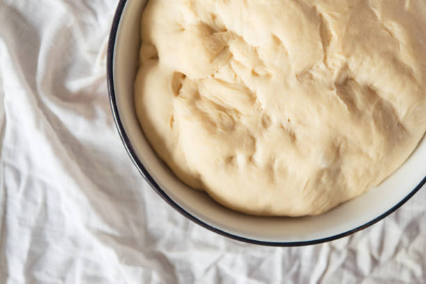 istock yeast dough for bread or pizza on a floured surface, with flour splash. Cooking bread. 1407069238