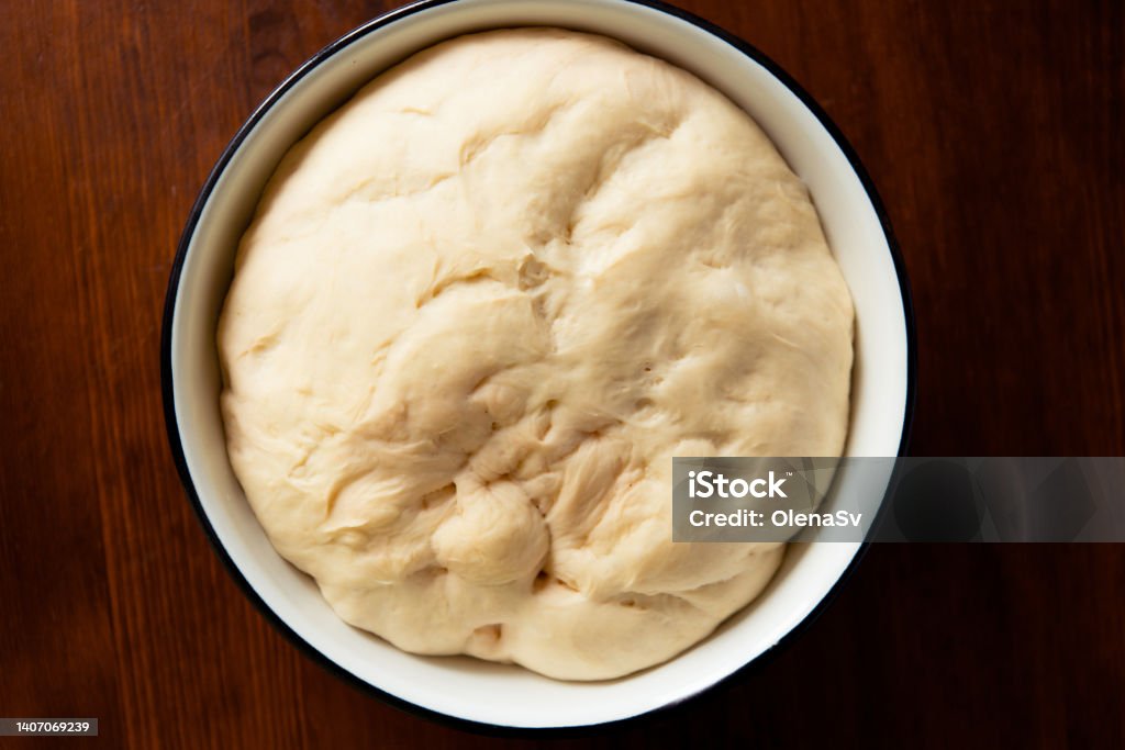 yeast dough for bread or pizza on a floured surface, with flour splash. Cooking bread. Proofing - Baking Technique Stock Photo