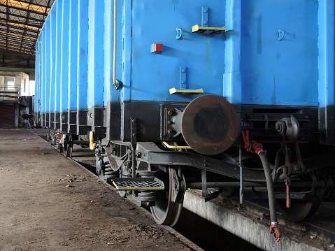 Blue wagon in an old workshop of wagons and railway locomotives. Place of repair and renovation for trains.