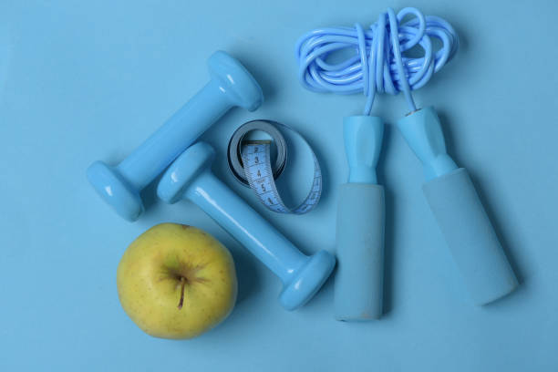 istock Fit shape concept. Apple, tape, dumbbells and skipping rope 1407071989