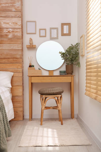 istock Stylish dressing table and mirror near white wall in bedroom. Interior design 1407072829
