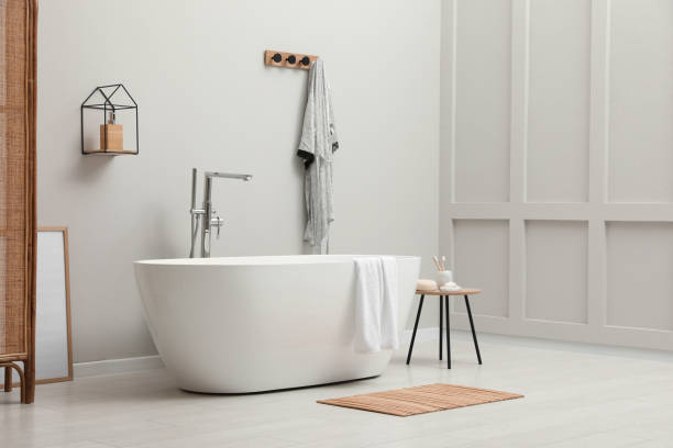 istock Modern ceramic bathtub with towel near white wall in room 1407072885