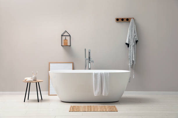 istock Modern ceramic bathtub near light wall indoors 1407072965