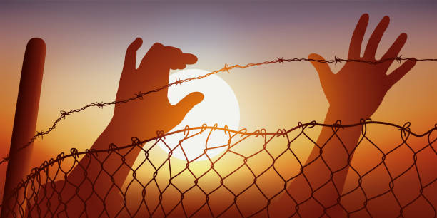 Symbol of migrant and oppressed peoples, with outstretched hands behind barbed wire. Concept of freedom and human rights with raised hands behind a fence and barbed wire, a symbol of oppressed peoples. immigrants crossing sign stock illustrations