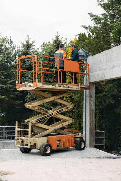 istock Scissor Lift Platform with workers on a construction site near the wall 1407074525