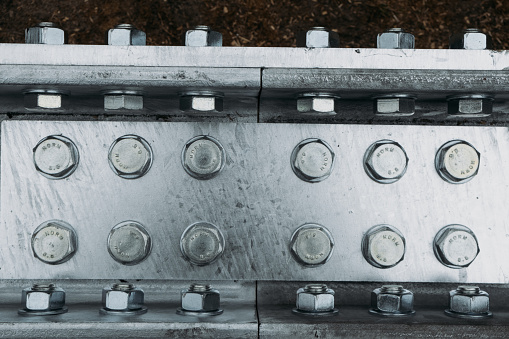 metal beam, silver color support with bolts, clean metal construction texture with copy space. Top view building element. Industrial abstract background with steel structure with rivets