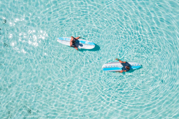 istock Surf instructor showing to surfing basics on surfboard 1407076279