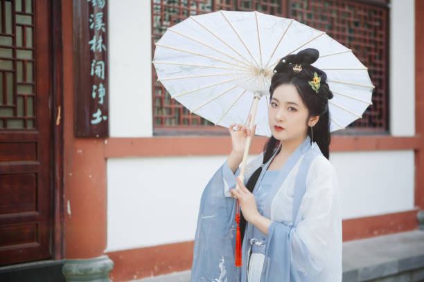 istock Chinese Hanfu beauties hold umbrellas outdoors in spring 1407078803