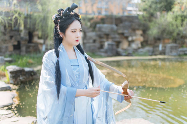 Women shoot arrows outdoors