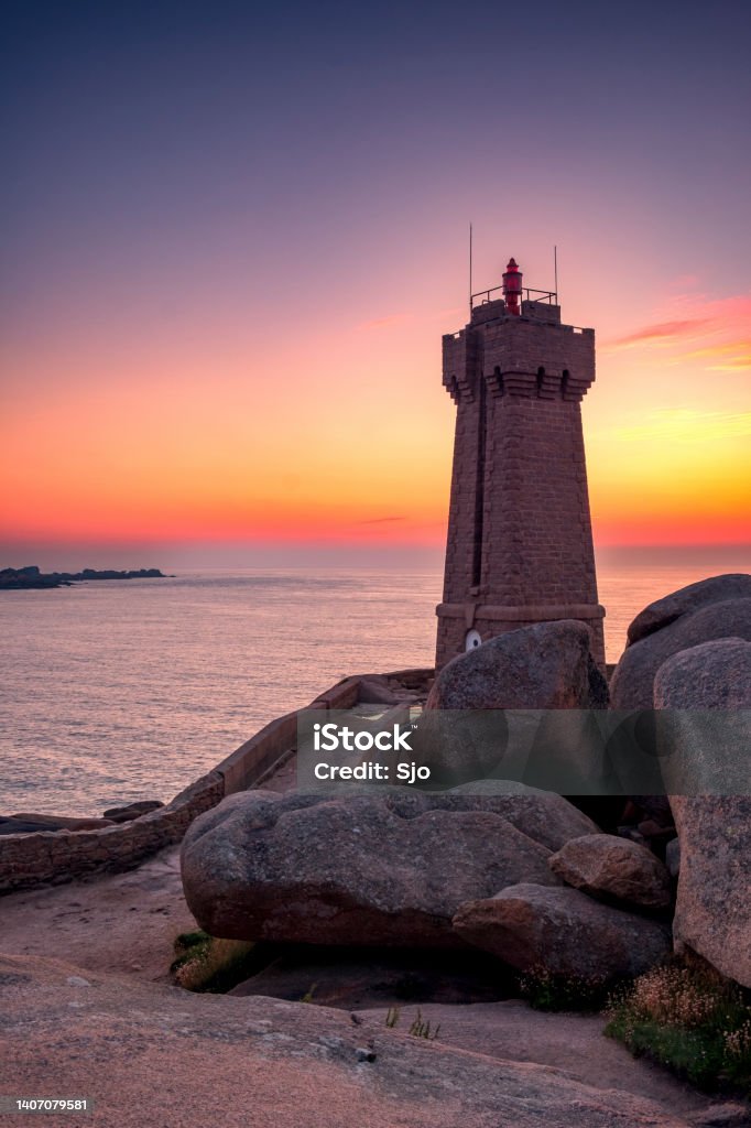 Ploumanach lighthouse at the pink granite coast in Brittany, France during sunset Ploumanach lighthouse or Phare de Men Ruz at the pink granite coast in Brittany, France during a beautiful summer sunset. Summer Stock Photo